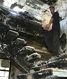 Un iraquí recoge libros de la destruida Librería Nacional.