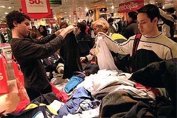 Dos jóvenes observan prendas rebajadas en una de las grandes superficies comerciales de la región.