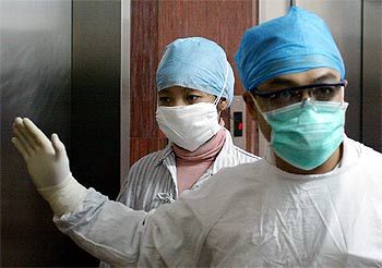 A la izquierda, la nueva afectada de SARS al entrar en el hospital del Pueblo número 8 de Guangzhou.