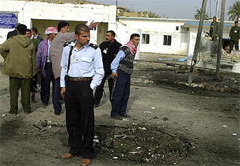 Un policía iraquí observa los daños causados ayer por la explosión de un coche cerca de una comisaria de Baquba.