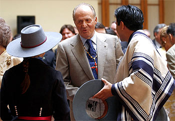 Don Juan Carlos charla con bailarines ataviados con trajes típicos en el Ayuntamiento de Santiago de Chile.