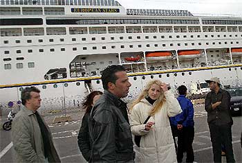 Un grupo de pasajeros del crucero, ayer ante el buque  European Stars. 