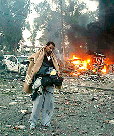 Un herido camina ante el hotel de Bagdad que sufrió ayer un atentado.