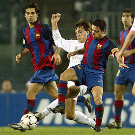 Xavi intenta superar a Mikel.