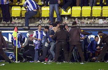 Varios miembros de la seguridad del estadio intentan auxiliar a los caídos.
