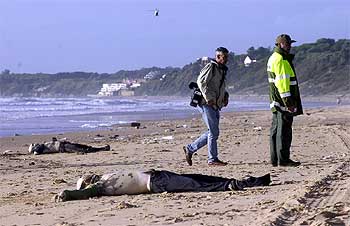 Los cuerpos de dos inmigrantes yacen en la playa de Rota días después del naufragio, tras ser devueltos por el mar.