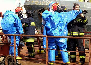 Bomberos con trajes especiales se preparan para revisar el  M-T Conakry  en Las Palmas.