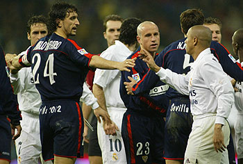 Roberto Carlos y Pablo Alfaro hablan durante un Madrid-Sevilla.