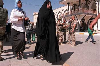 Jóvenes chiíes pasan ante un control de soldados españoles en Diwaniya.