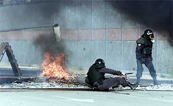Un agente de la Guardia Civil tropieza con una de las barricadas en la carretera de la esclusa de Sevilla.