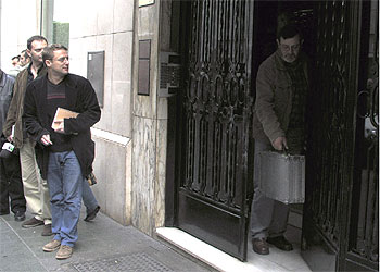 Un agente de la policía científica sale, ayer, del portal de Juan Asensio tras recoger pruebas.