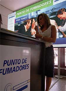 Una mujer enciende un cigarrillo en un 