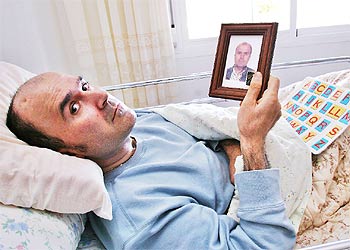 Indalecio Llort, en su casa de Palma, con una foto anterior al coma.