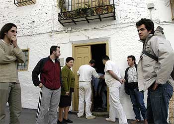 Varias personas esperan para entrar en la casa de las  caras de Bélmez. 