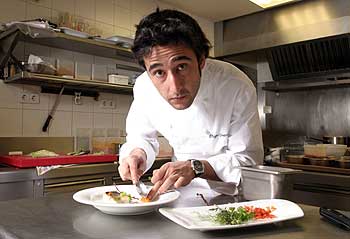 El  chef  Diego Herrero, en el restaurante Club Allard. Abajo, lubina con café, calabaza, vainilla, pan de hongos y piñones.