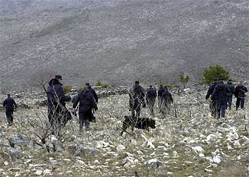 Policías serbobosnios rastrean la zona de Stolac donde desapareció ayer el avión del presidente de Macedonia.