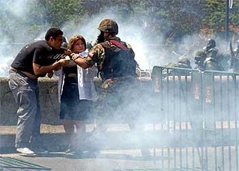 Dos manifestantes forcejean con un guardia nacional durante los disturbios del pasado viernes en Caracas.
