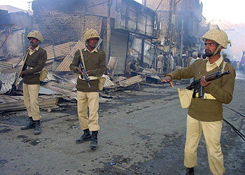 Soldados paquistaníes cortan una céntrica calle de la ciudad de Quetta destrozada por la explosión.