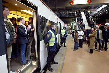 Los guardias de seguridad de la estación de Atocha controlaban ayer, como es habitual, la subida y bajada de pasajeros de los trenes de cercanías. La afluencia de viajeros era mucho menor de lo normal. rnrn LUIS MAGÁN
