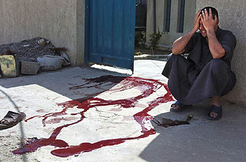 Un hombre llora junto a la sangre de su hermano, muerto durante un tiroteo con  marines  el viernes en Faluya.