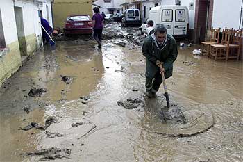 Un vecino de Rincón de la Victoria retiraba ayer agua y barro de una de las calles.