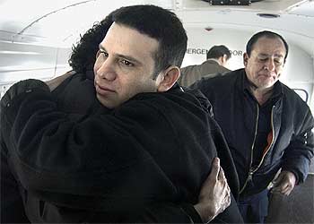 Camilo Mejía abraza a un familiar en Miami delante de su padre, el cantante Carlos Mejía Godoy.