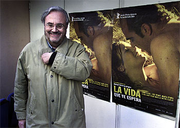 Manuel Gutiérrez Aragón, delante del cartel de su película  La vida que te espera. 