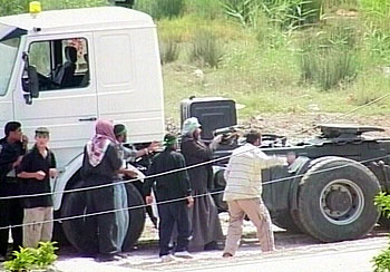 Un iraquí dispara, parapetado tras un camión, contra el cuartel español en Nayaf.