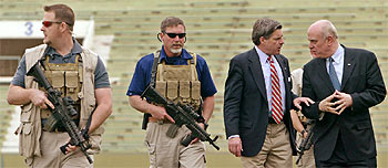 Paul Bremer (segundo por la derecha) conversa el pasado jueves en Bagdad con uno de sus asesores, junto a dos guardaespaldas. rnrn REUTERS