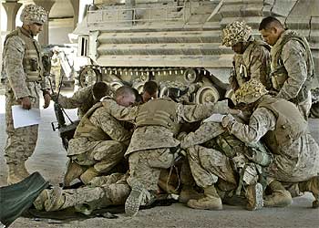 Un grupo de  marines  reza el jueves ante el cuerpo de un compañero muerto en la batalla de Faluya.