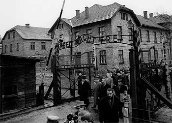 Supervivientes y participantes en el juicio de Auschwitz en Francfort ante las puertas del campo de concentración el 14 de diciembre de 1964.