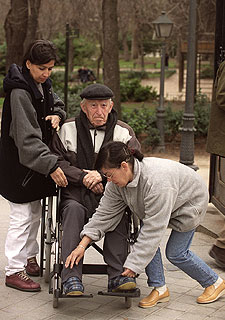 Una persona mayor es atendida por dos mujeres.