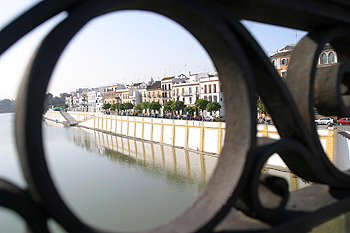 Vista de las fachadas de la trianera calle Betis,  desde el puente de Isabel II sobre el río Guadalquivir, en Sevilla.