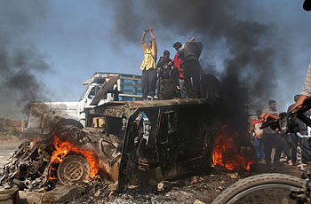 Varios iraquíes celebran la destrucción de un vehículo de EE UU en una calle de Bagdad.