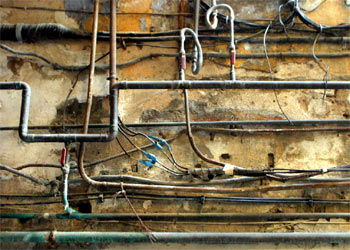 Conducciones eléctricas y de agua entre las que hay unas antiguas tuberías de plomo.