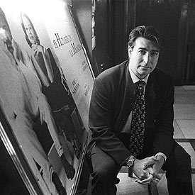 Luis Ramírez, junto a un cartel de  El hombre de la Mancha. 