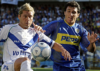 Zárate, a la izquierda, en pugna con Burdisso, del Boca, en un partido de Liga.