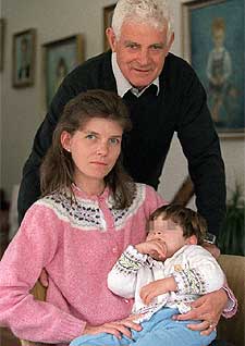 María, una niña afectada de paralisis cerebral, junto a su madre y su abuelo.