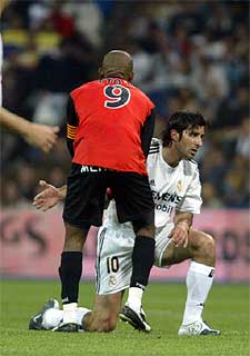 Eto'o ayuda a Figo a levantarse.