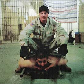 Un soldado de EE UU se sienta sobre un prisionero.