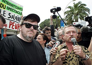Michael Moore, a la izquierda, y José Bové, durante la manifestación de los intermitentes celebrada ayer en La Croisette de Cannes.rnrn  REUTERS