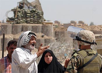 Un iraquí se dirige a un  marine  estadounidense ante la prisión de Abu Ghraib.