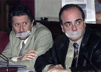 Los ediles Enrique Salvo y Francisco Trigueros, con la boca tapada, durante el pleno de ayer.