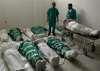 Dos enfermeros, junto a los cadáveres de palestinos muertos en la operación militar israelí de ayer en Rafah, en la franja de Gaza. rnrn ASSOCIATED PRESS