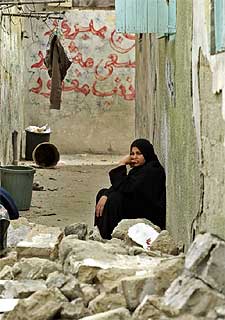 Una mujer palestina se sienta entre las ruinas de su casa en Rafah.rnrn  REUTERS