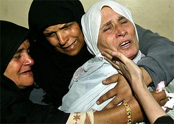 La madre de un joven palestino muerto en el ataque israelí del pasado miércoles (derecha) llora durante el funeral celebrado ayer en Rafah.