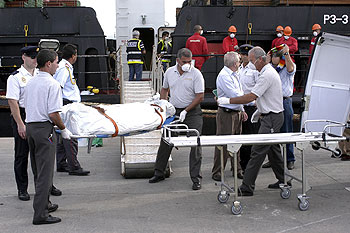Policías y bomberos sacan a uno de los cadáveres encontrados en las bodegas del  Nathalie Bolten. 