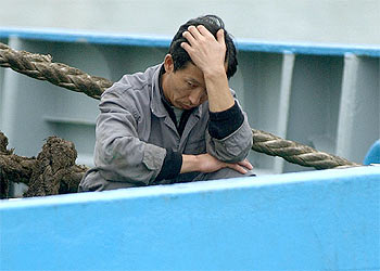 Uno de los tripulantes del  Wisteria , tras quedar atracado el buque en el puerto de Ribeira.