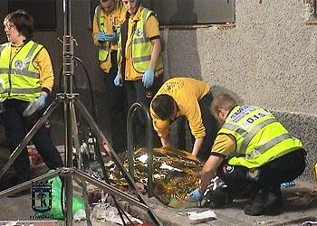 Miembros del Samur cubren a uno de los cadáveres en el lugar del tiroteo.
