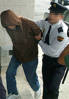 Un policía traslada a comisaría al capitán del  Wisteria. 